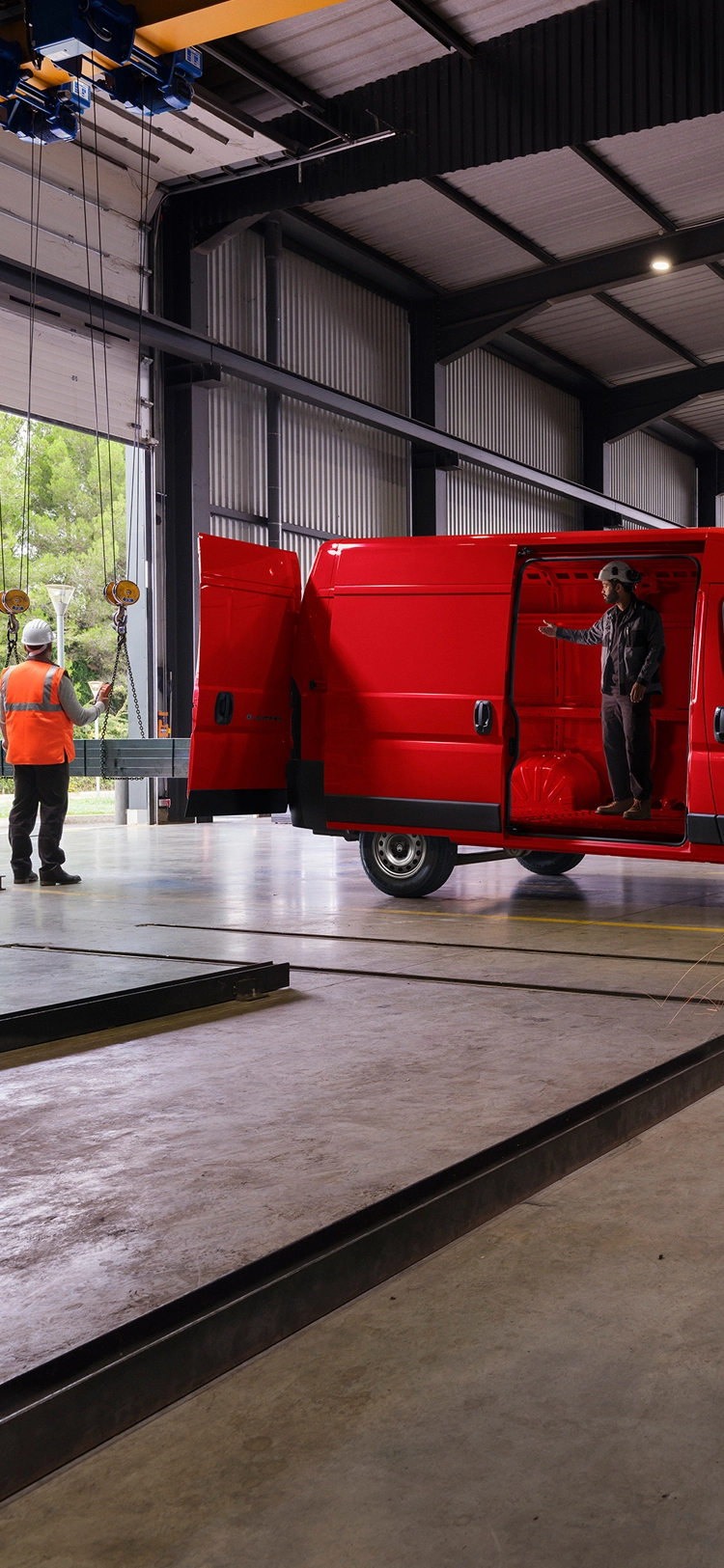 Side view of a red Citroën Relay in a workshop environment, highlighting robust exterior design and professional usability.