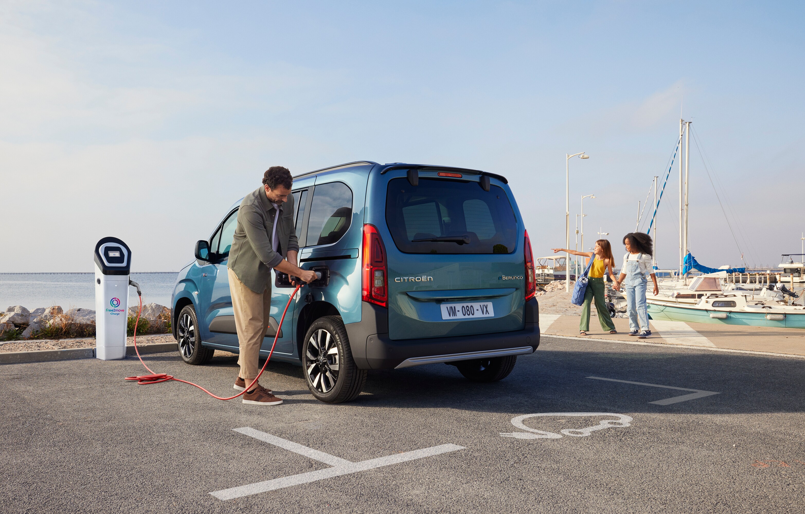 Rear three‑quarter view Berlingo charging at a Free2move station showing safety, efficiency, technology and confident use